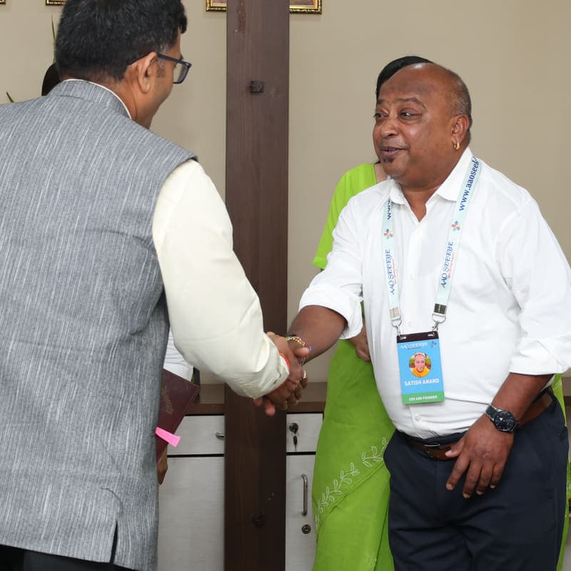 Aao Seekhe founder Satish Anand shaking hands with a university partner