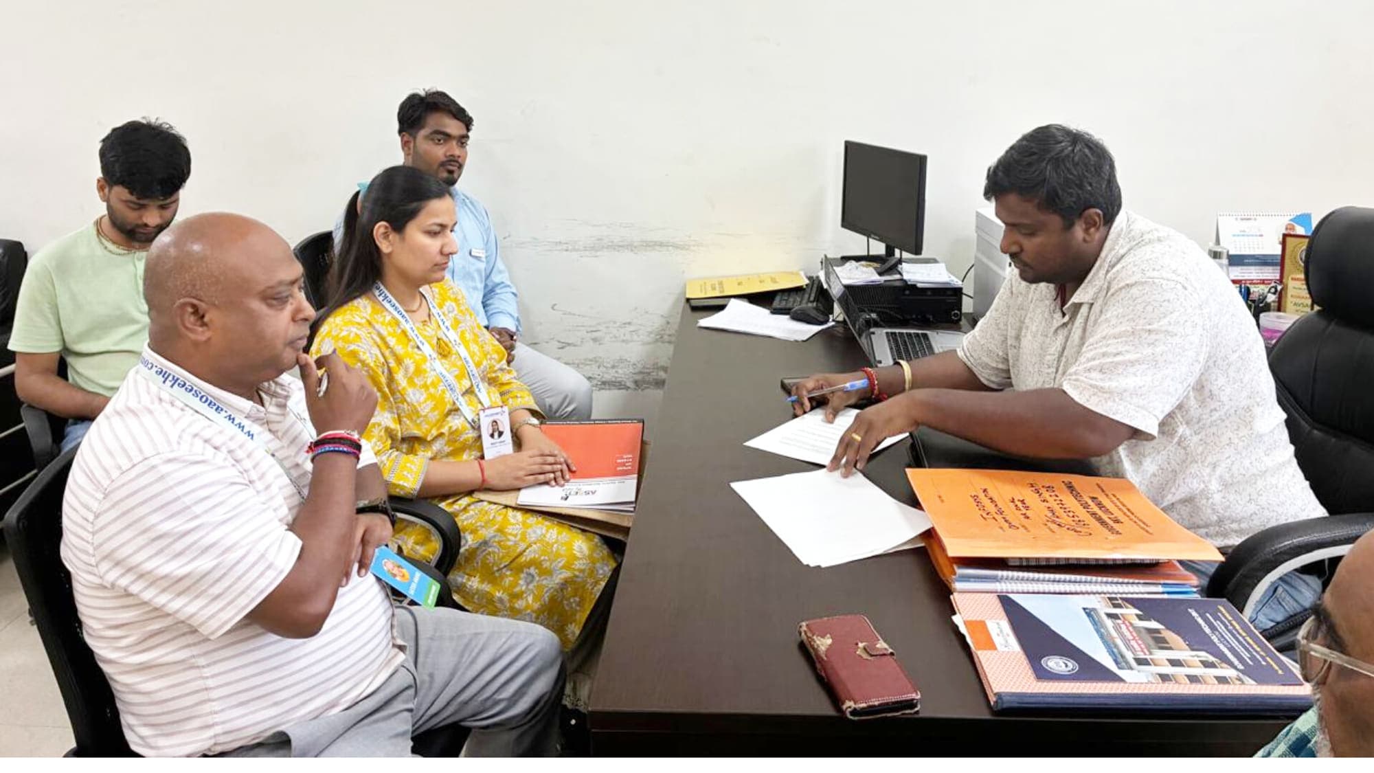 Aao Seekhe counsellors reviewing application paperwork with students across an office table
